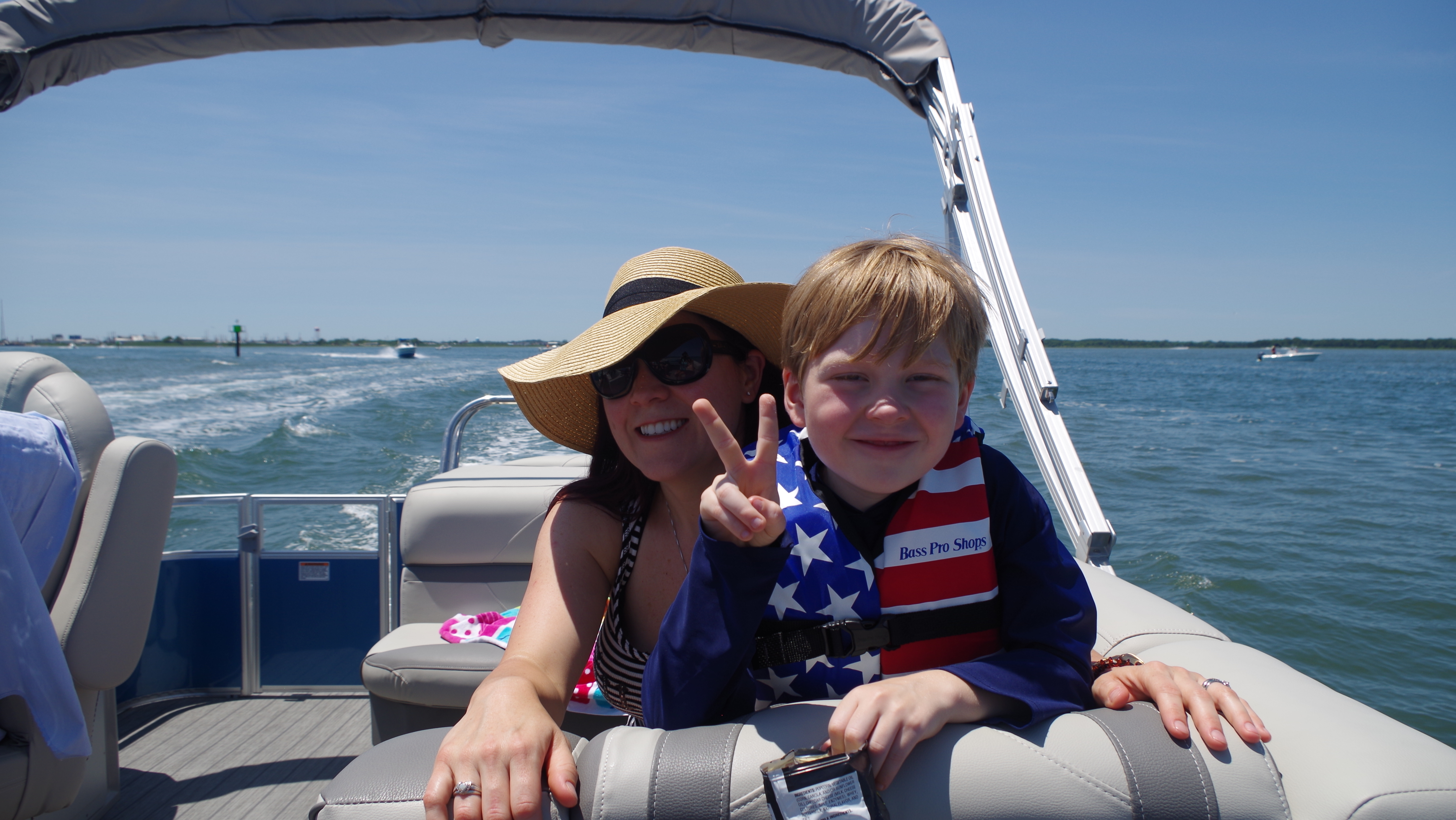 A mom and child on board a pontoon boat cruising the Cape May harbor
